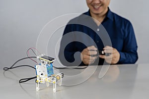 Teacher collects a handmade metal and plastic robot. STEM education for children and teenagers, robotics and electronics. DIY