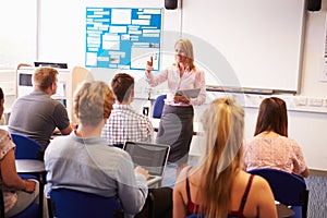 Teacher With College Students Giving Lesson In Classroom