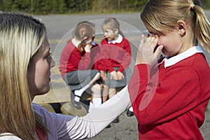 Teacher Comforting Victim Of Bullying In Playground