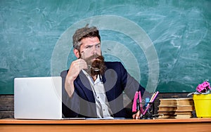 Teacher concentrated bearded mature schoolmaster listening with attention. Teacher formal wear sit table classroom