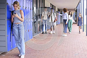 Teacher Confronting Students Teasing Or Bullying Unhappy Teenage Girl Outdoors At High School photo