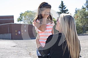 Teacher consoling a girl on schoolyards