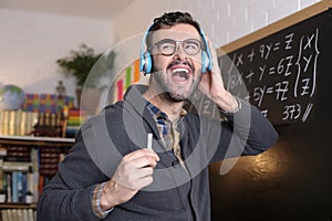 Teacher dancing with headphones in classroom