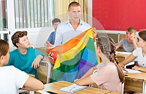 Teacher discussing with teenage students about LGBT in classroom
