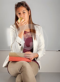 Teacher eat apple at desk