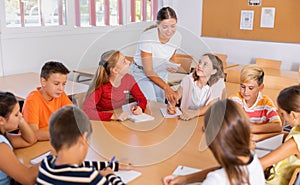 Teacher explaining subject to children during lesson in school