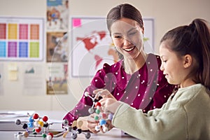 Teacher And Female Student In School Science Class Studying Molecular Model