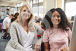 Teacher And Female Student Work On Computer In College Library