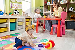 Teacher with girls playing at kindergarten