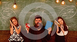 Teacher and girls pupils in classroom, chalkboard on background. Children and teacher with drawn by chalk horns