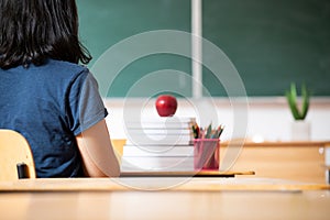 Teacher giving books to her students at school