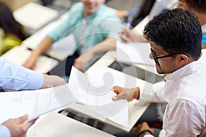 Teacher giving exam test to student man at lecture