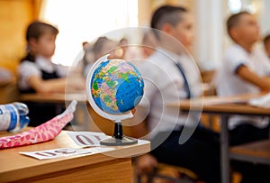 Teacher giving geography lesson to school children in classroom