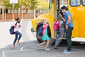 Teacher giving high five to kids while entering in bus