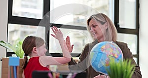 Teacher giving high five to little girl, a close-up
