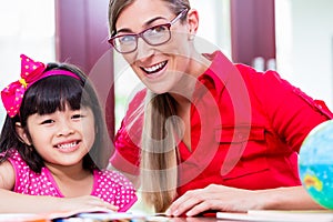 Teacher giving language lessons to Chinese child