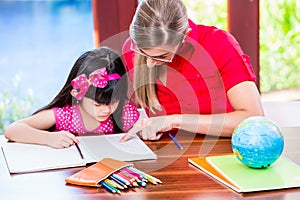 Teacher giving language lessons to Chinese child