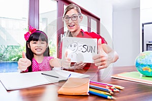 Teacher giving language lessons to Chinese child