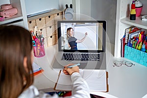 Teacher giving lesson online on video chat. Teenager girl studying at home looking at tutor at laptop screen photo