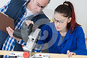 Teacher grading carpentry apprentice