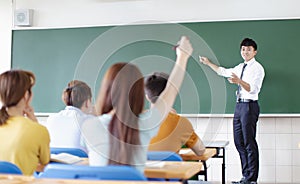 Teacher with group of college students in classroom