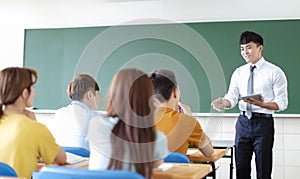 Teacher with group of college students in classroom