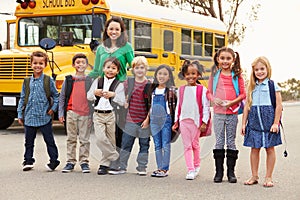 Teacher and a group of elementary school kids at a bus stop