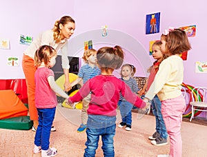 Teacher and group of kids in kindergarten