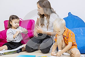 Teacher guiding her pupils in folding papers