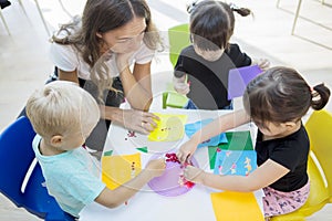 Teacher guiding her pupils to make stickers