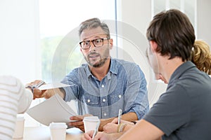 Teacher handing copies to students