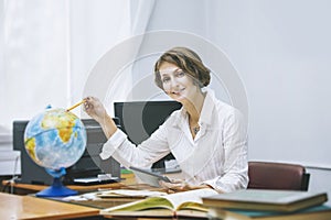 Teacher happy young woman in a classroom with electronic tablet