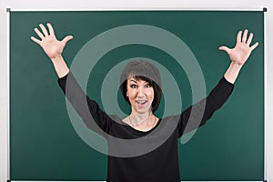 Teacher having idea and posing by chalk Board, learning concept, green background, Studio shot