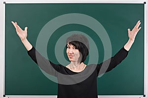 Teacher having idea and posing by chalk Board, learning concept, green background, Studio shot