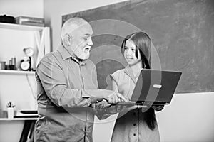 Teacher help schoolgirl. Little girl with man tutor study hold laptop. Pedagogue of digital science. Online lesson