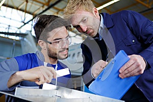 teacher helping apprentice mechanic