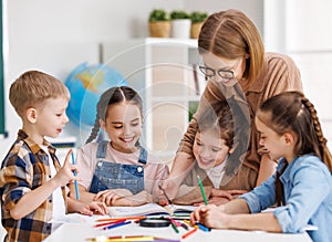 Teacher helping children with schoolwork photo