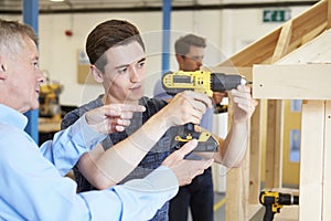 Teacher Helping College Student Studying Carpentry