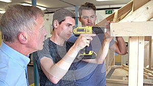 Teacher Helping College Student Studying Carpentry