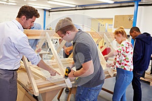 Teacher Helping College Students Studying Carpentry