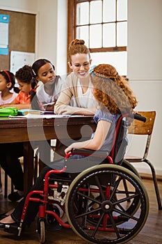 Teacher helping a disabled pupil