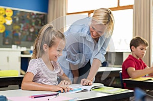 Teacher helping girl to study