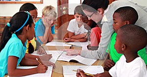 Teacher helping her pupils during class