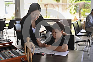 Teacher helping her student drawing in art class.