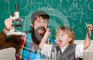 Teacher helping kid with their homework in classroom at school. Child and teacher in the class room. Happy little