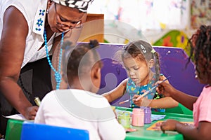 Teacher helping kids in a preschool class, close up