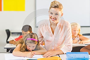 Teacher helping kids with their homework in classroom