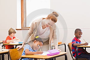 Teacher helping pupil in classroom