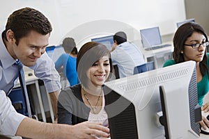 Teacher Helping Student In Computer Lab