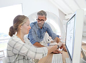 Teacher helping student girl working on computer